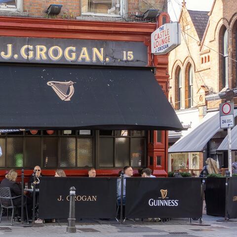 A man walks past the red-painted front of a popular Dublin pub
